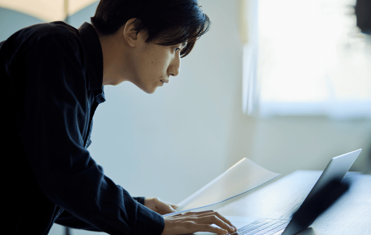 ノートパソコンに向かって作業するビジネスパーソン