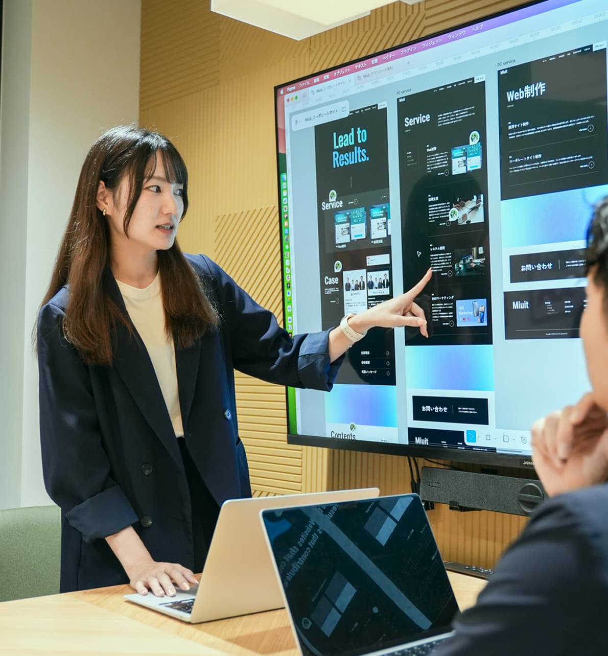 モニターに映したFigmaデザインを指し示しながら説明する Miuit のメンバー