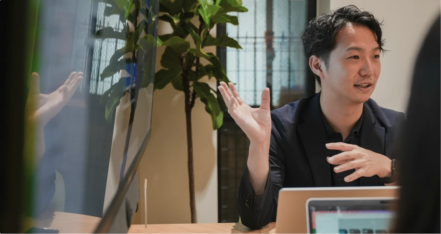 ミーティングで身振りを交えて話すメンバー