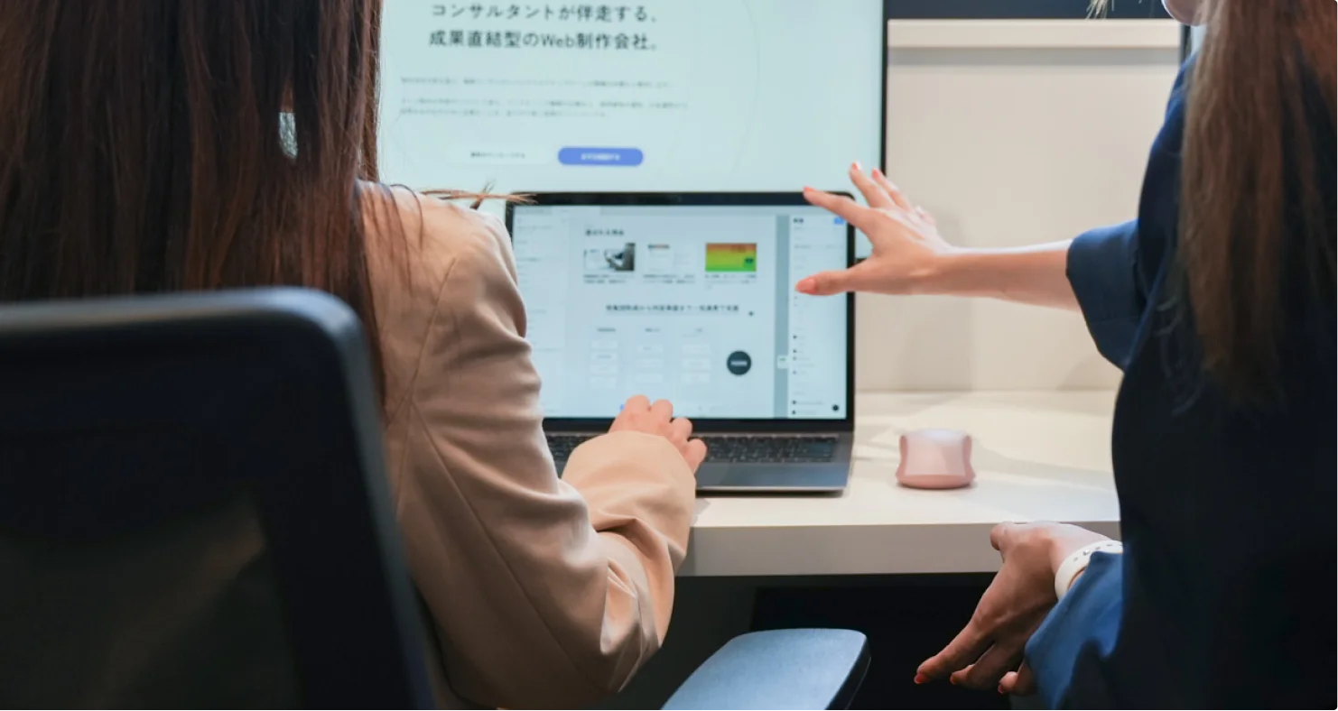 ノートPCの画面を見ながら話し合うメンバー
